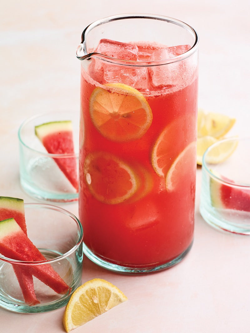A glass of watermelon lemonade on a table.